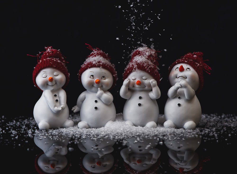 Un grupo de muñecos de nieve parados uno al lado del otro