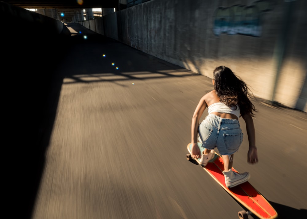 a woman riding a skateboard down a street