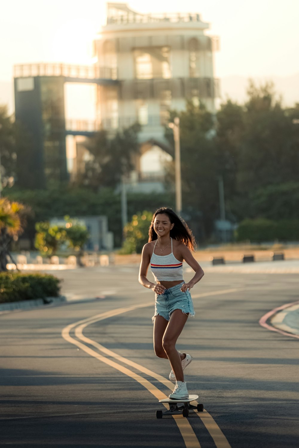 a woman riding a skateboard down a street