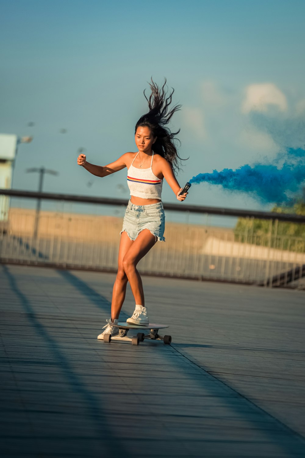 a young girl riding a skateboard down a sidewalk