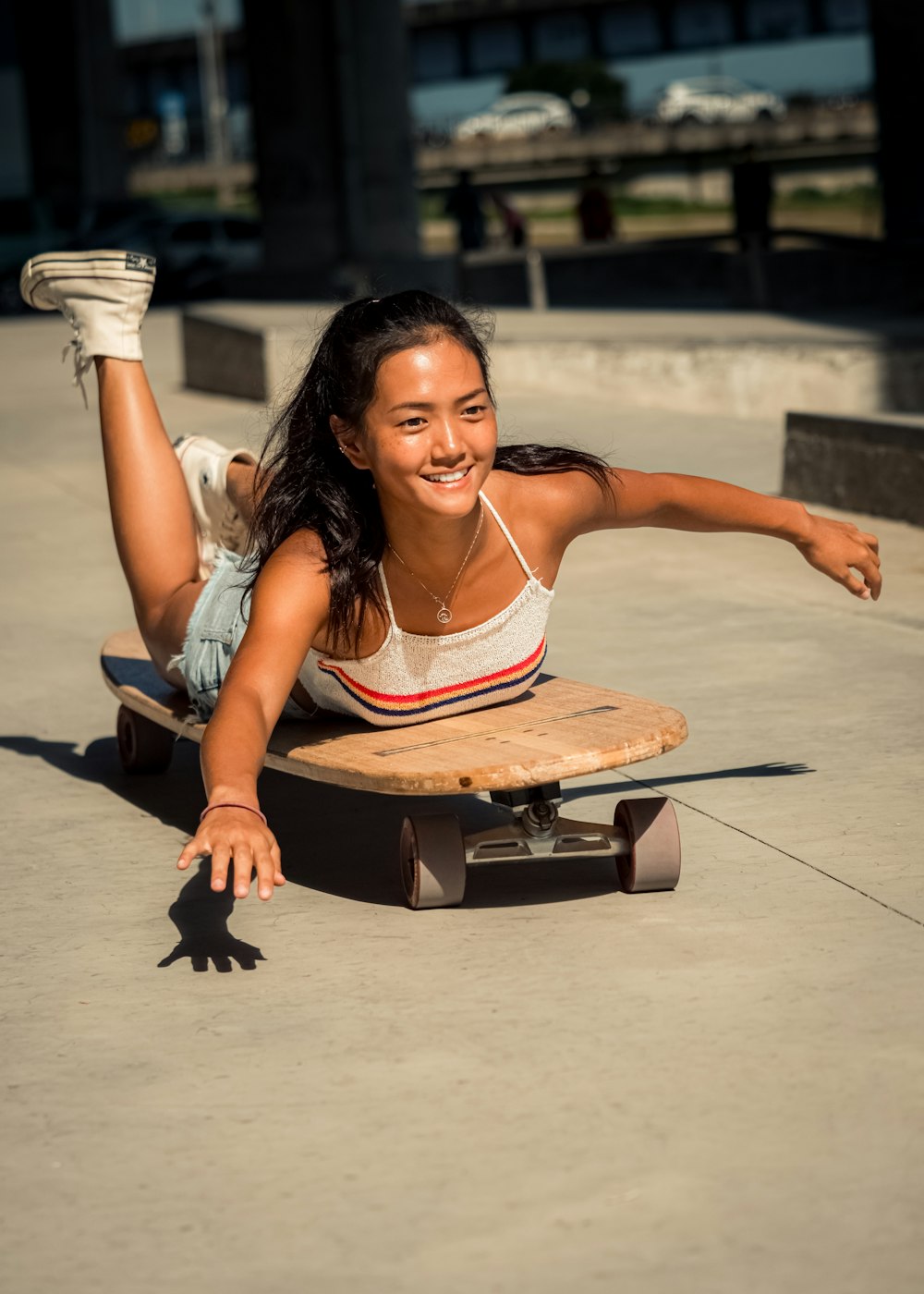 a woman laying on top of a skateboard on the ground