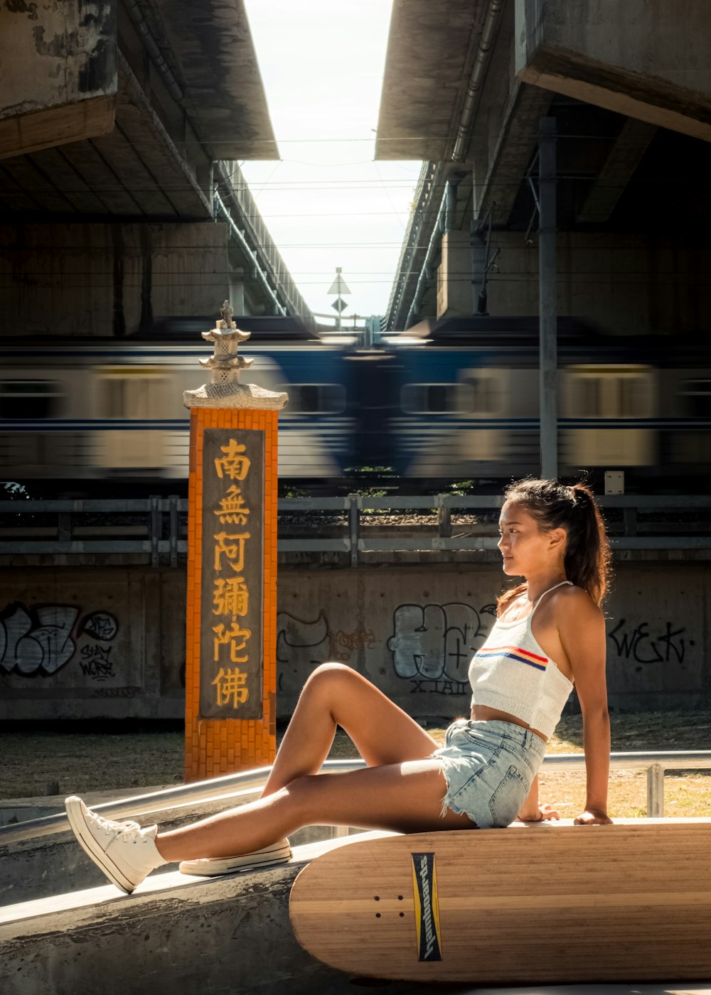 a woman sitting on a skateboard in a train station