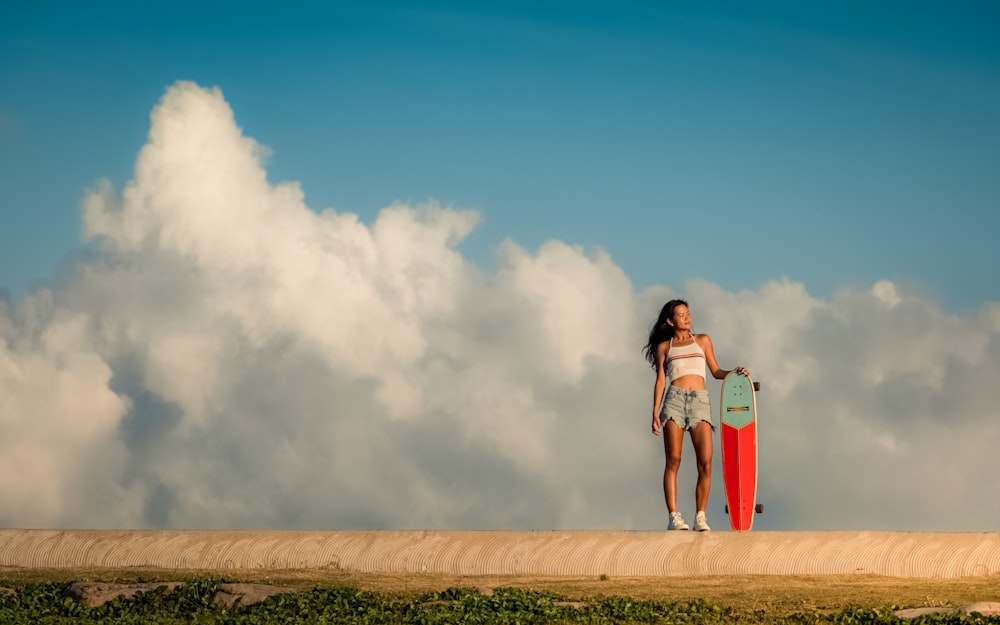 a woman holding a surfboard standing on a beach