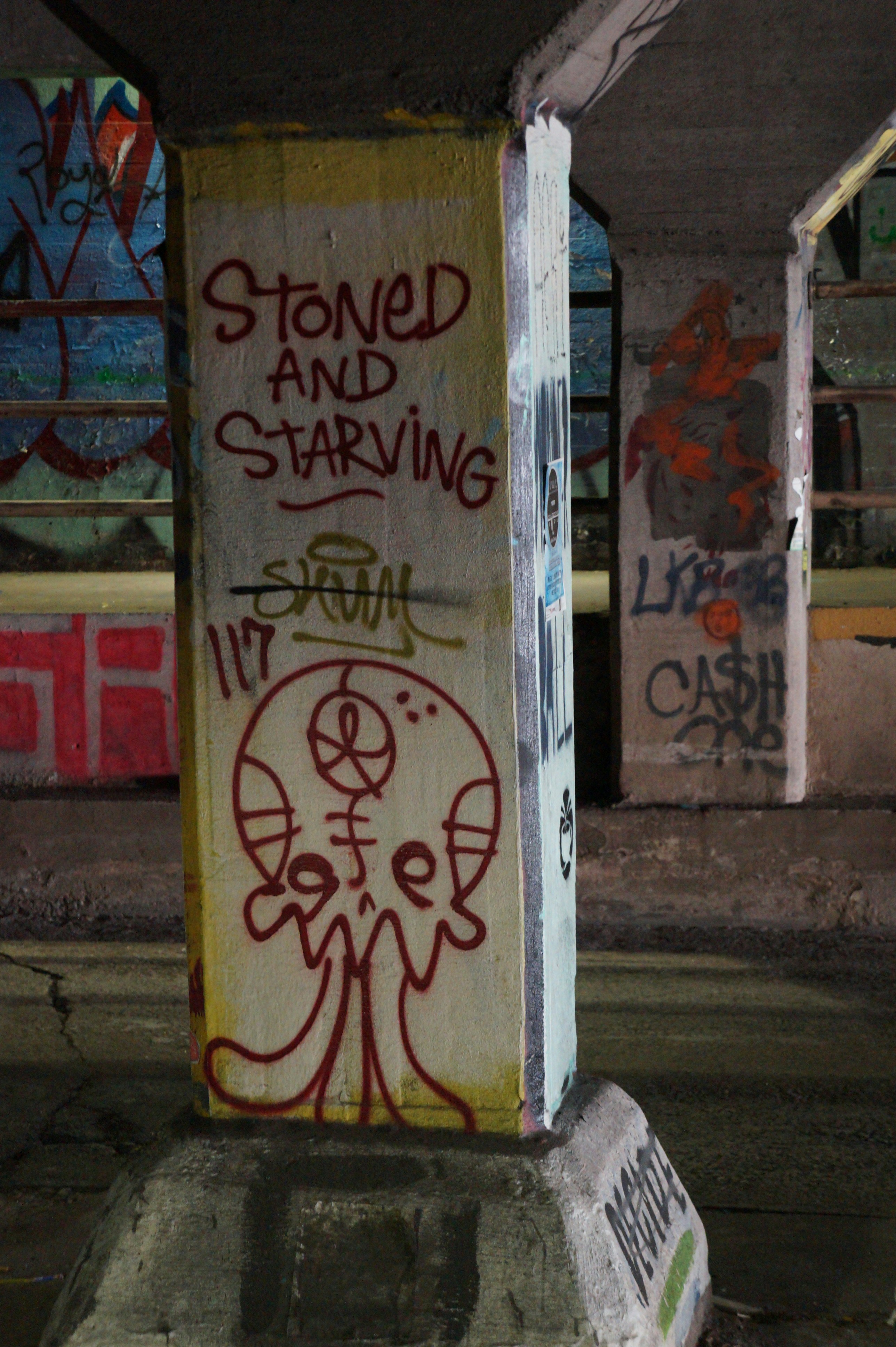 a box covered in graffiti sitting on the side of a road