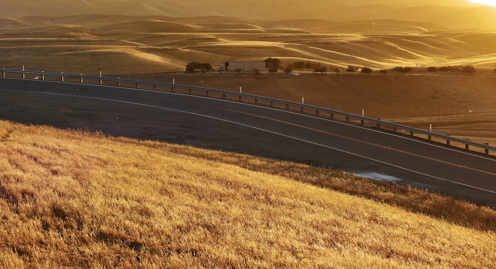 a road going down a hill in the middle of a field