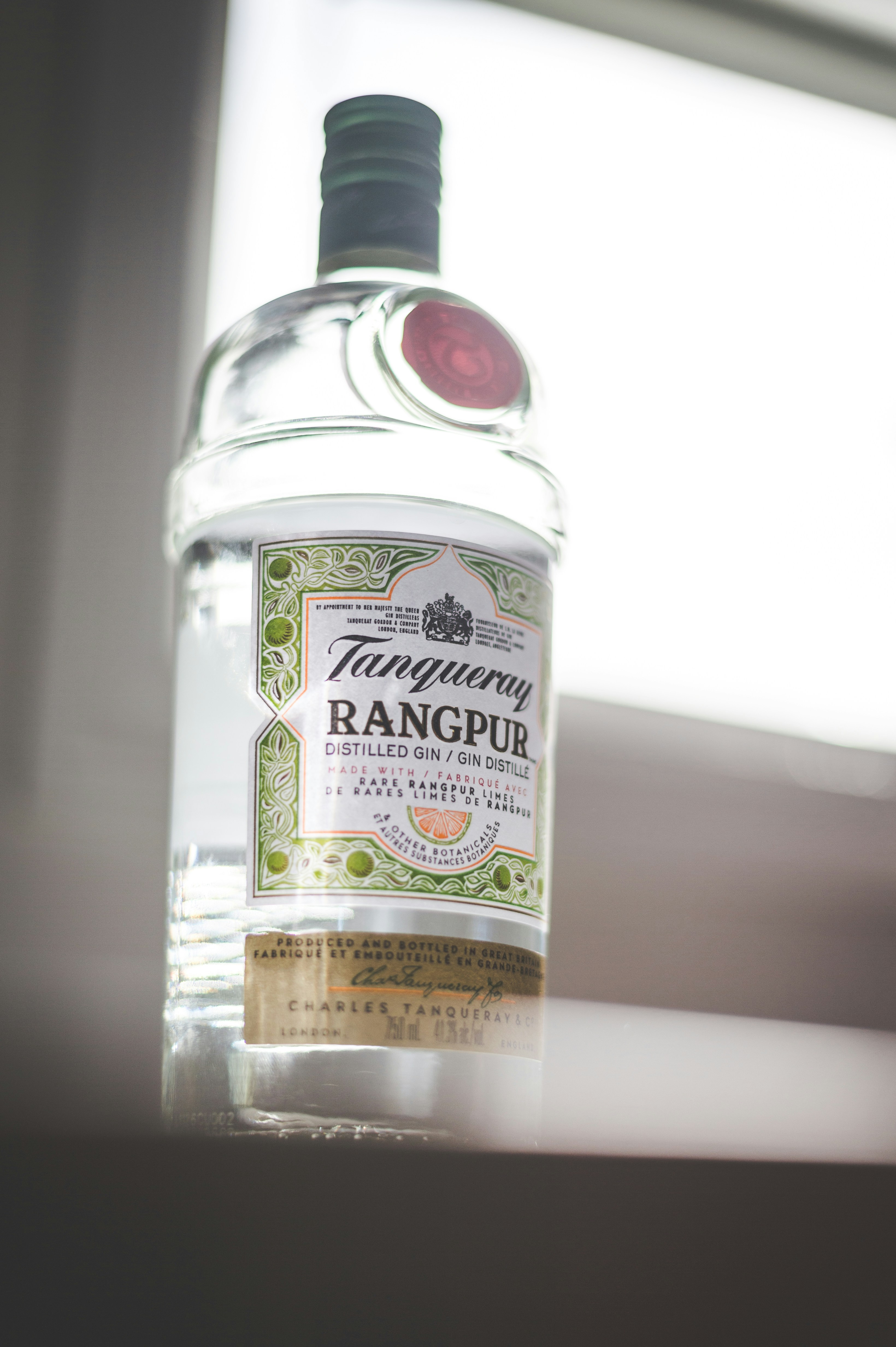 a bottle of alcohol sitting on a window sill