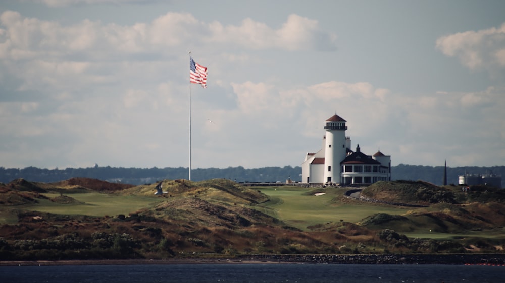 a white lighthouse with a flag on top of it