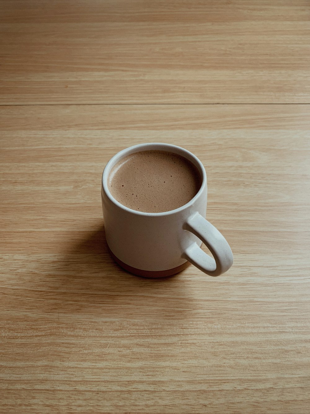 a cup of coffee sitting on top of a wooden table