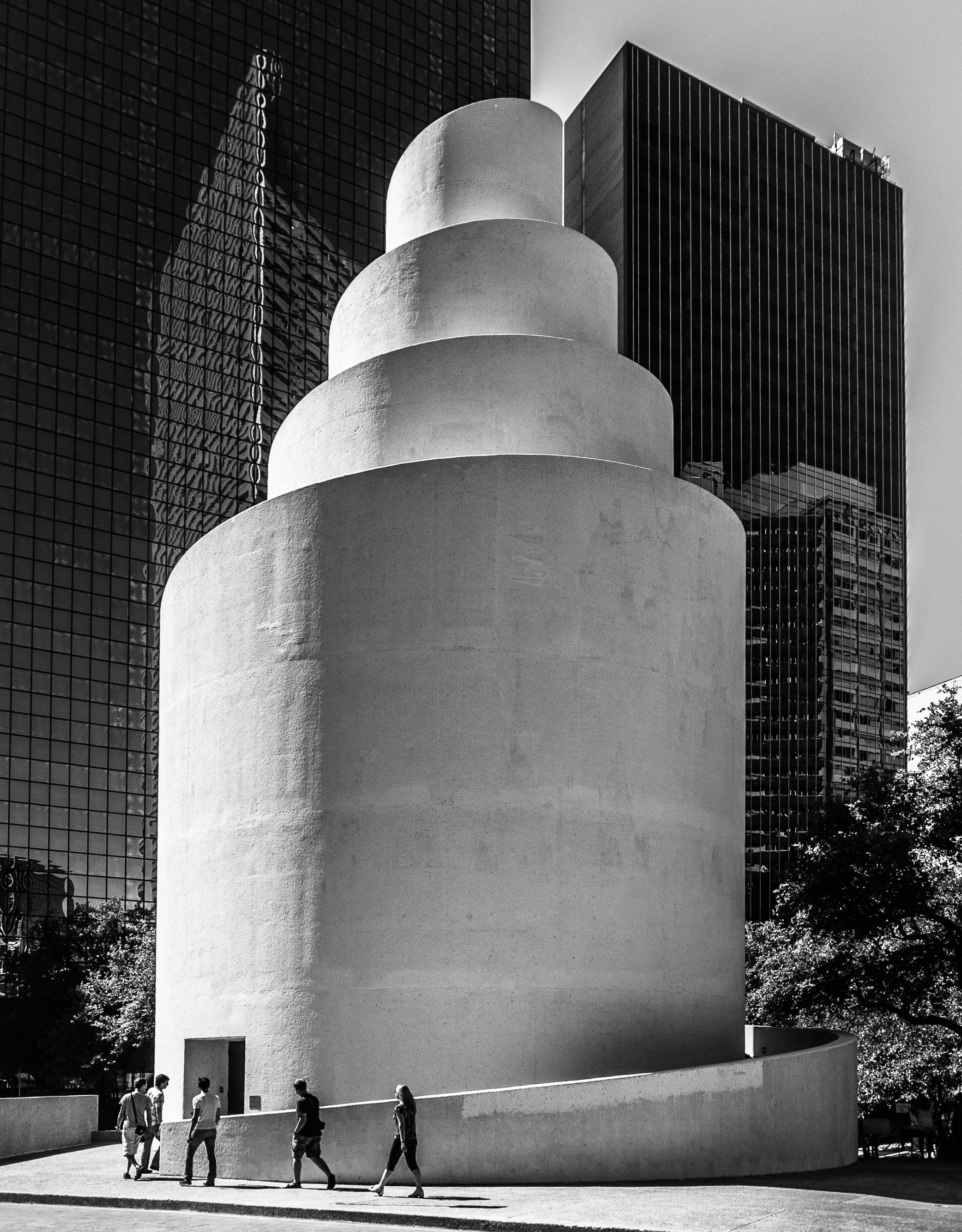 une photo en noir et blanc de personnes marchant devant un bâtiment