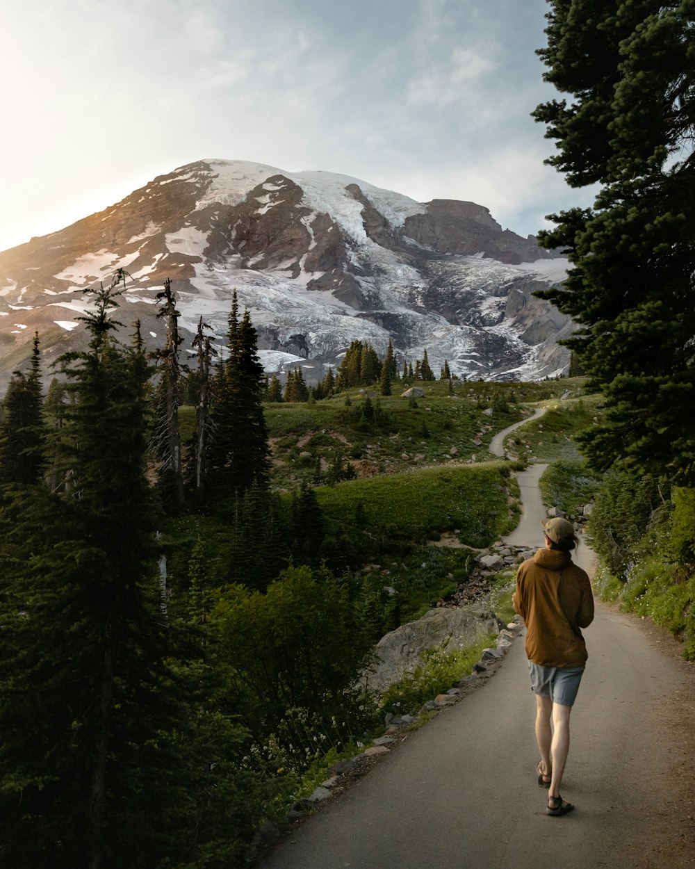 a person walking down a path towards a mountain