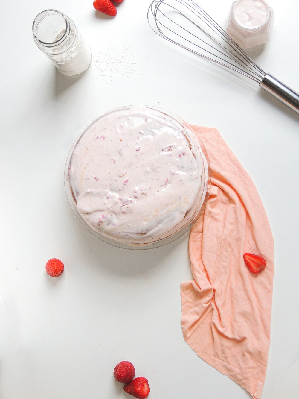 a bowl of whipped cream next to a whisk and a whisk