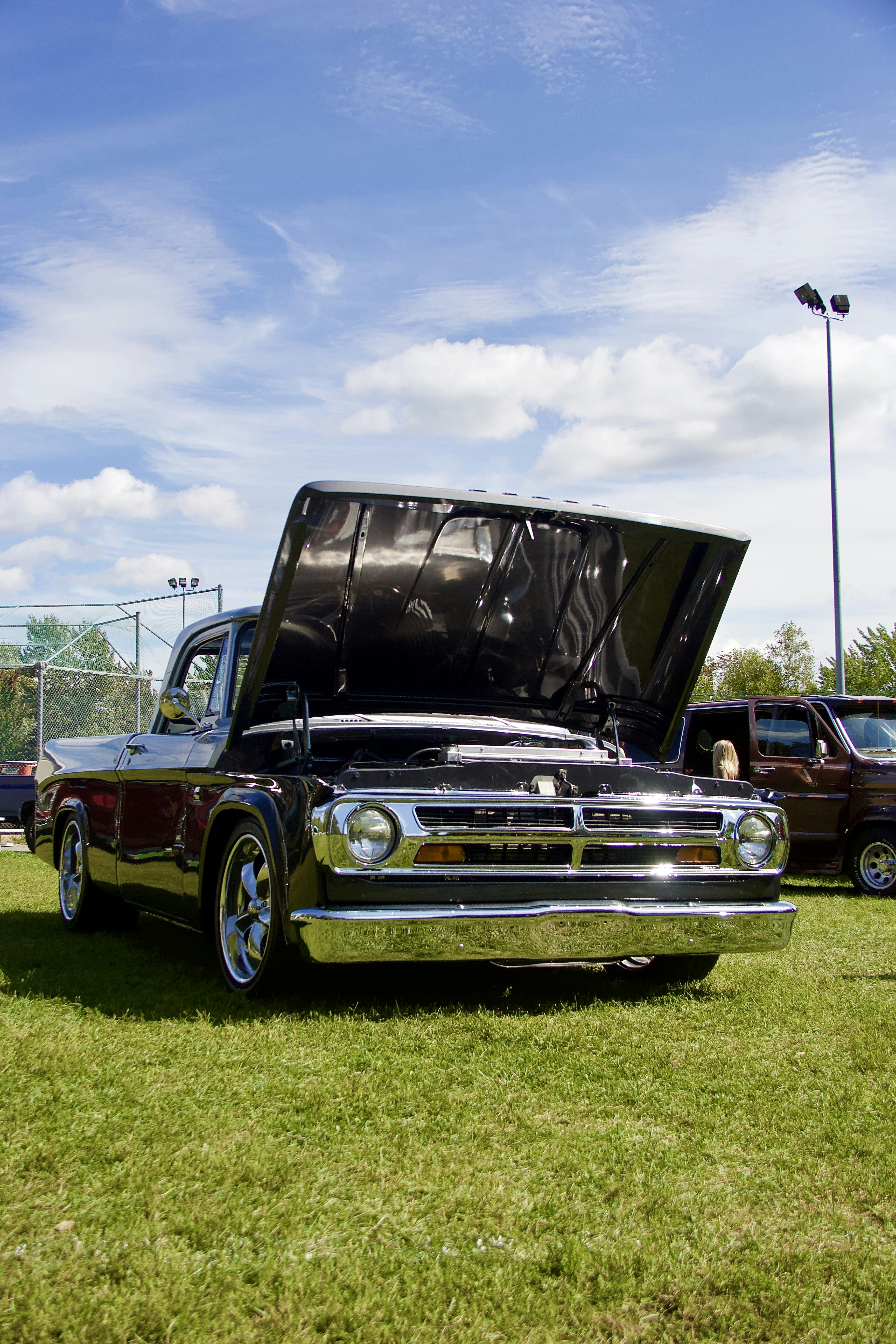 a truck with its hood open sitting in the grass