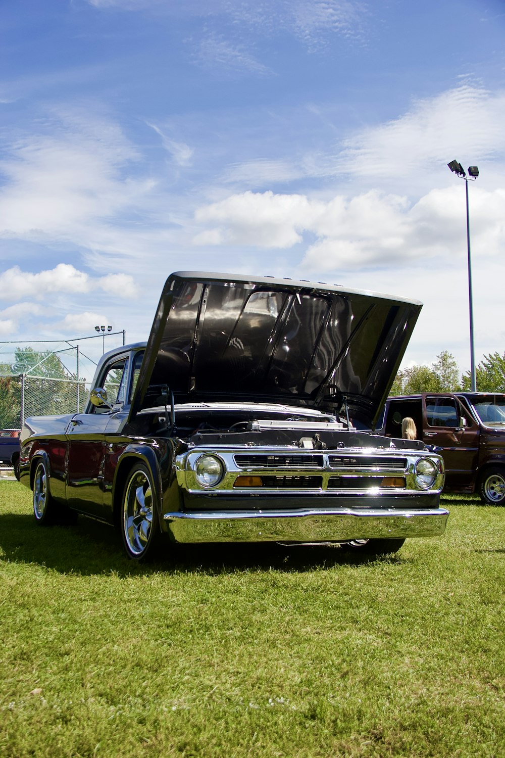 a truck with its hood open sitting in the grass