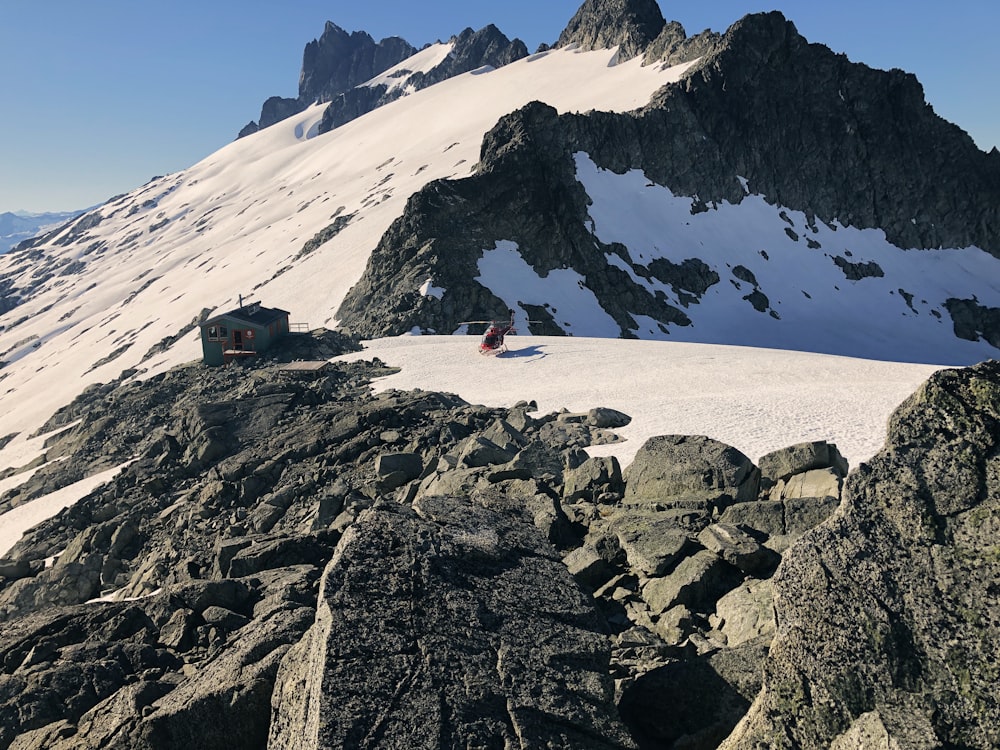 a snow covered mountain with a couple of people sitting on top of it