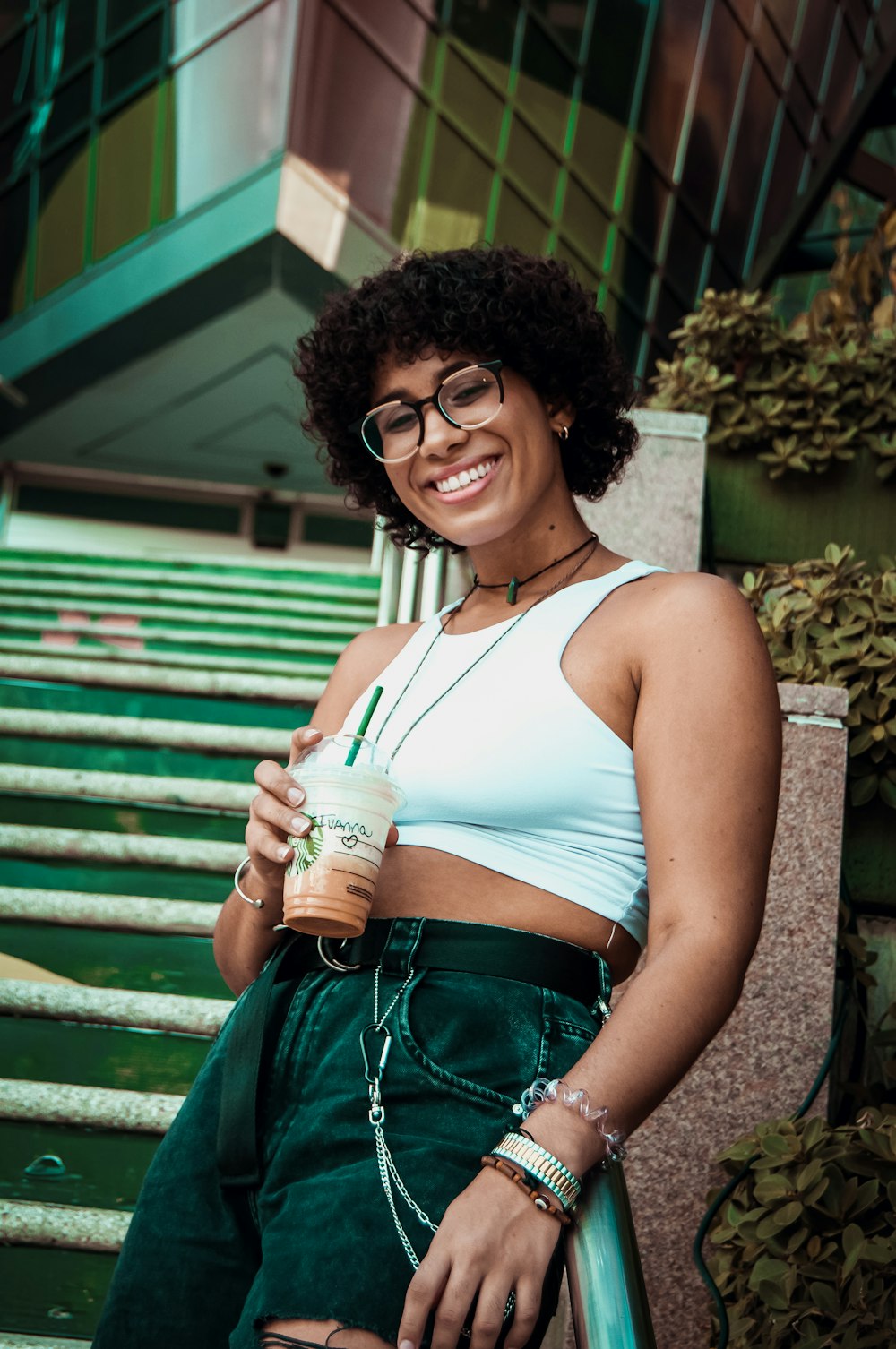 a woman with glasses holding a cup of coffee