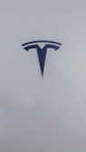 A sleek, metallic logo in the shape of a T sits prominently against a smooth, white background, conveying a sense of modern elegance and sophistication.