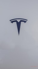A sleek, metallic logo in the shape of a T sits prominently against a smooth, white background, conveying a sense of modern elegance and sophistication.