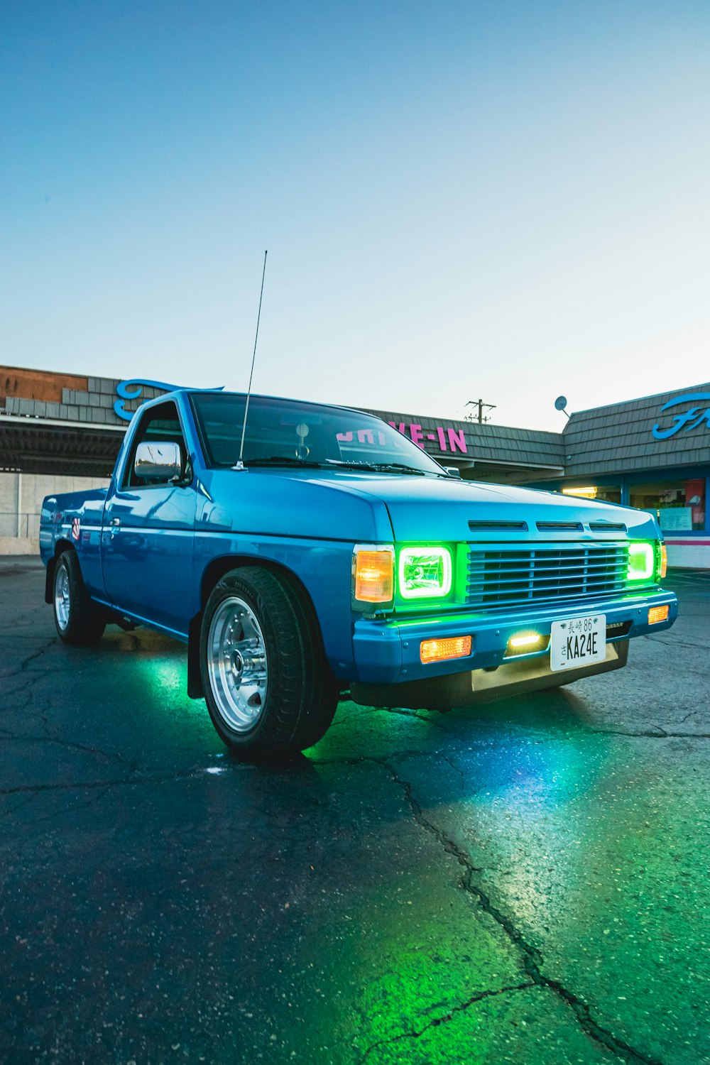 a blue pick up truck parked in a parking lot