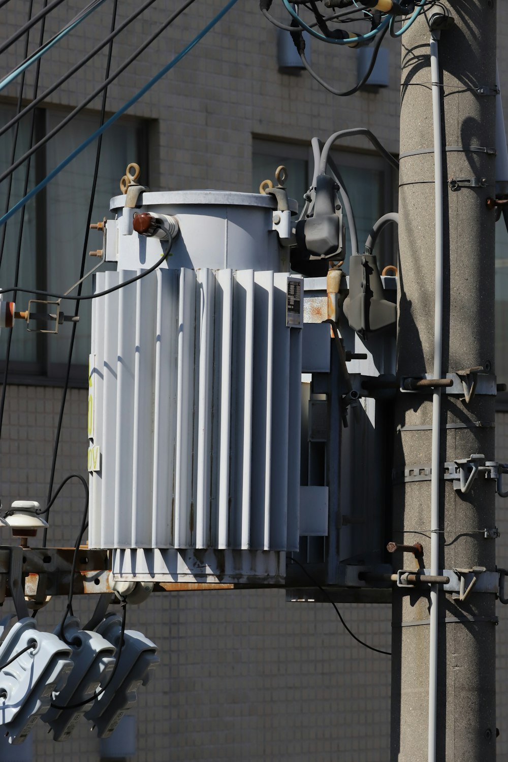 an electric pole with an electrical transformer attached to it