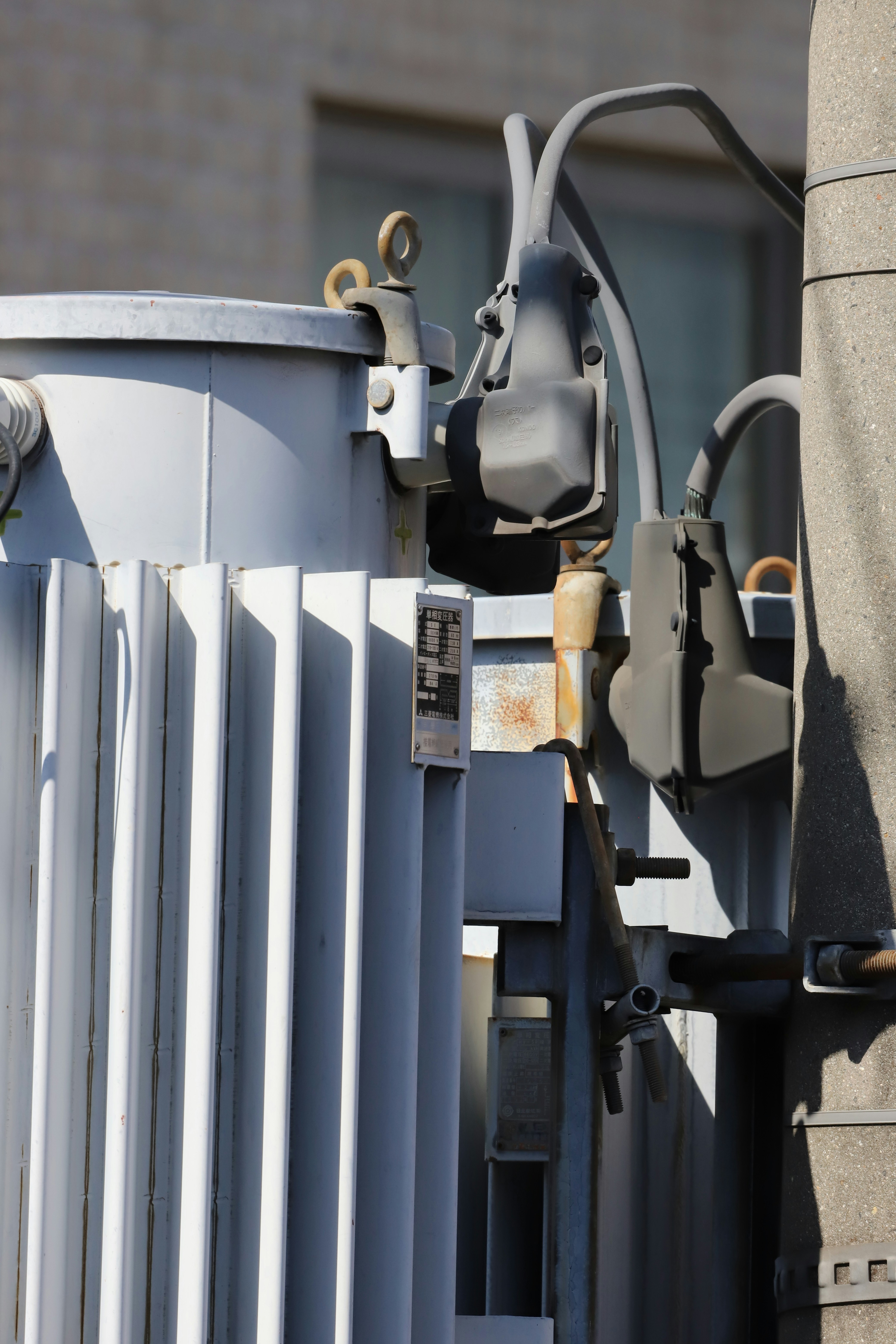 Close-up of high-voltage transformer equipment in daylight, industrial power facility