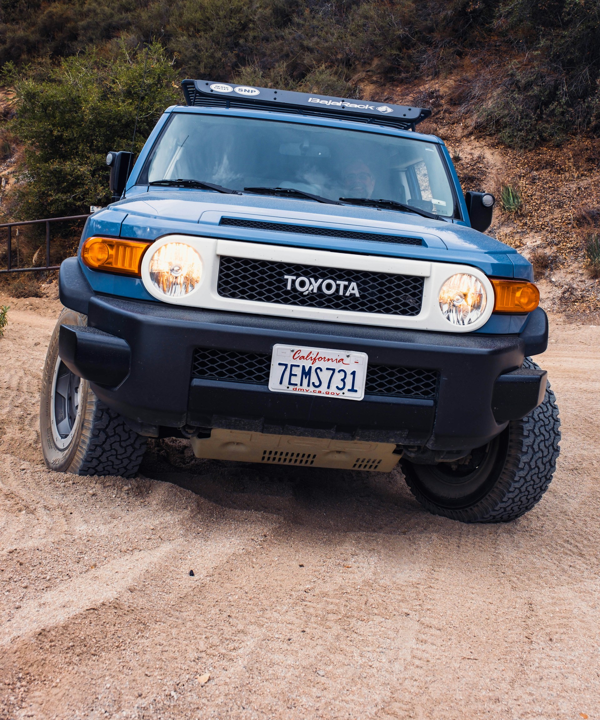 a blue toyota truck parked on a dirt road