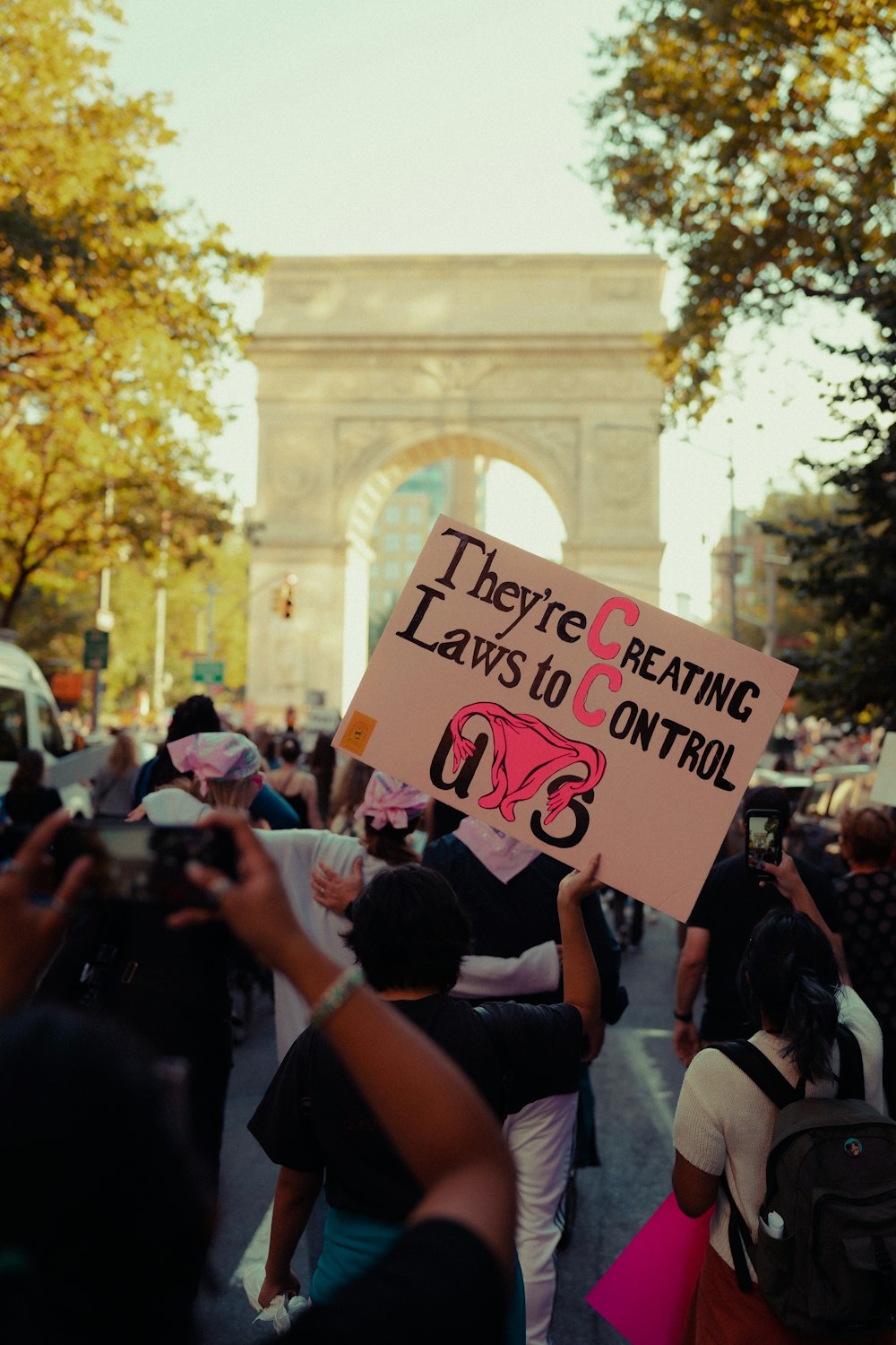 a group of people walking down a street holding signs