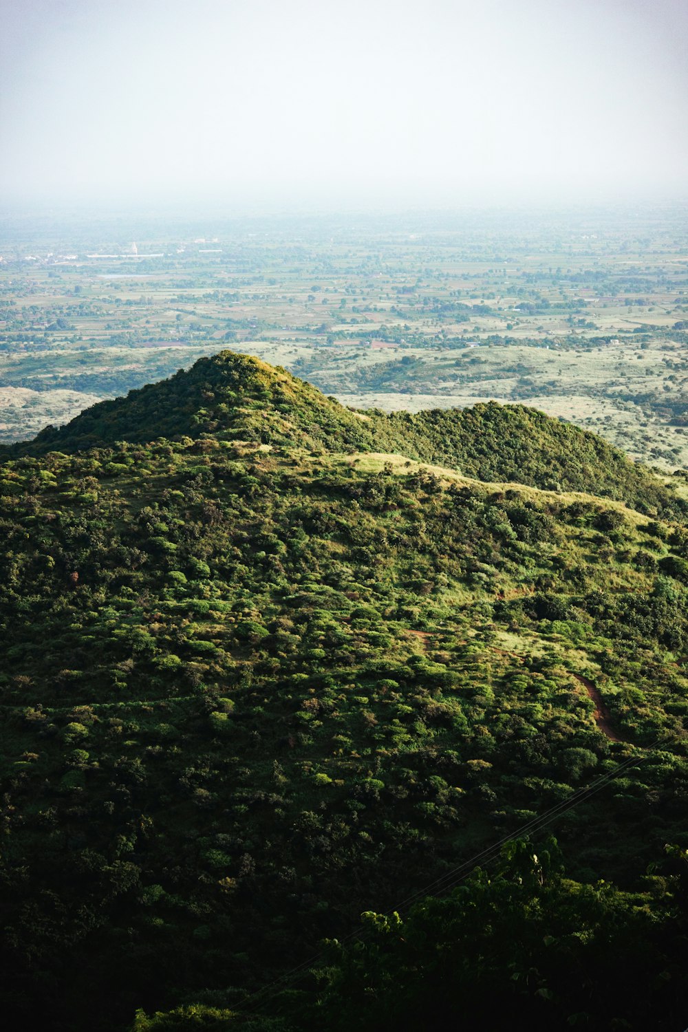 a hill covered in green grass with a sky background