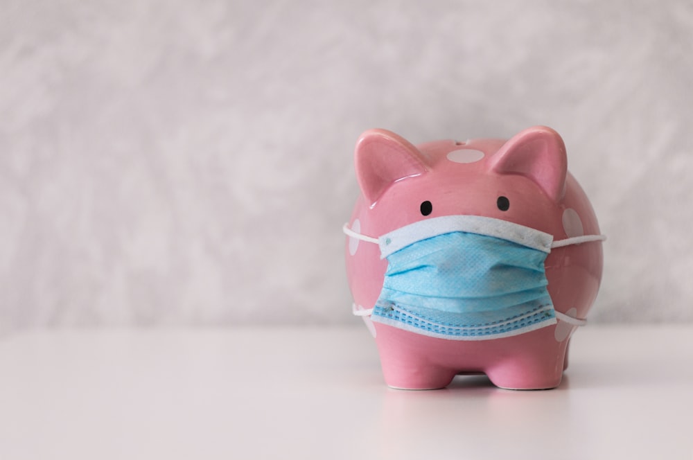 a pink piggy bank wearing a face mask