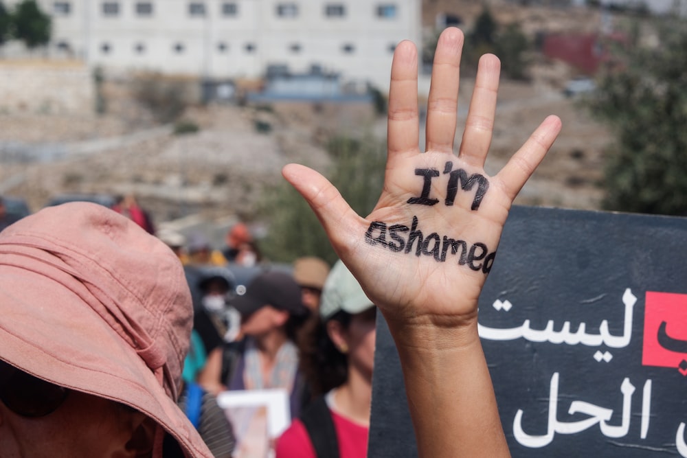 a person holding up their hand with writing on it