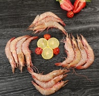 Close-up of succulent shrimp arranged neatly on a wooden platter.