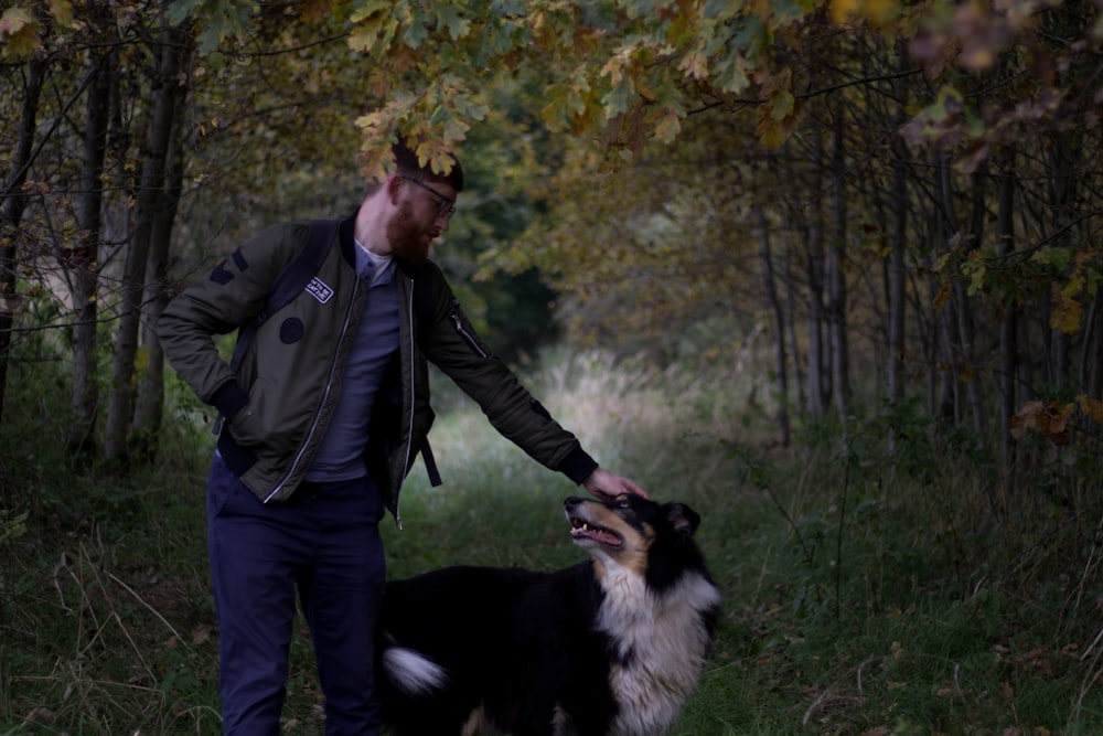 a man walking a dog through a forest