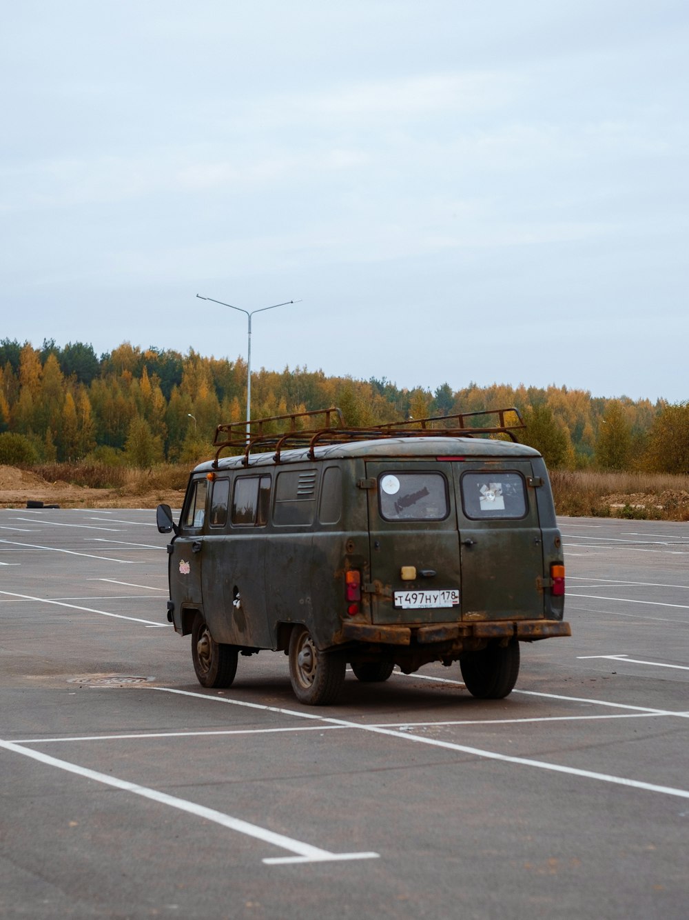 a van parked in a parking lot with trees in the background