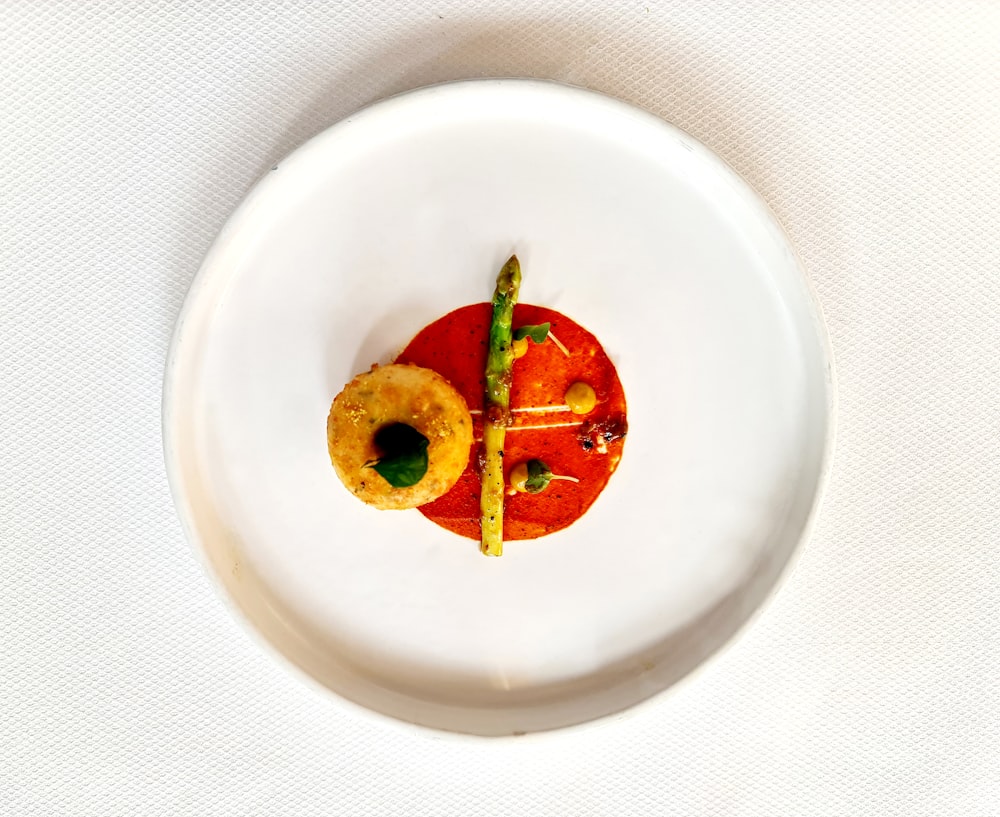 a white plate topped with a cut in half tomato