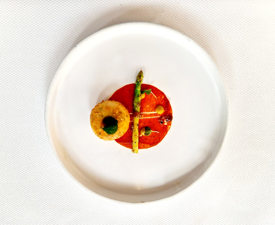 a white plate topped with a cut in half tomato,