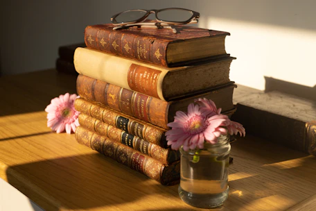 a stack of books sitting on top of a wooden table