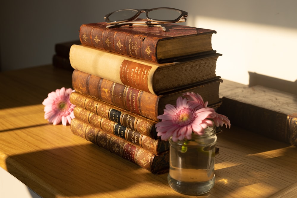 a stack of books sitting on top of a wooden table