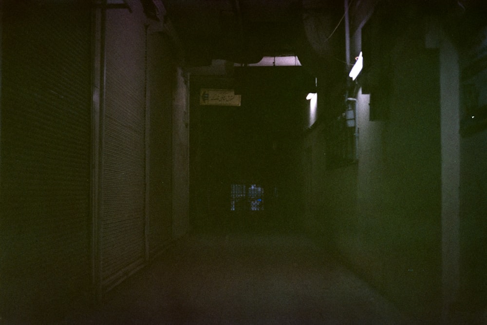 a dark hallway with a clock on the wall