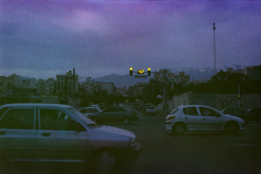 a city street filled with lots of traffic under a purple sky