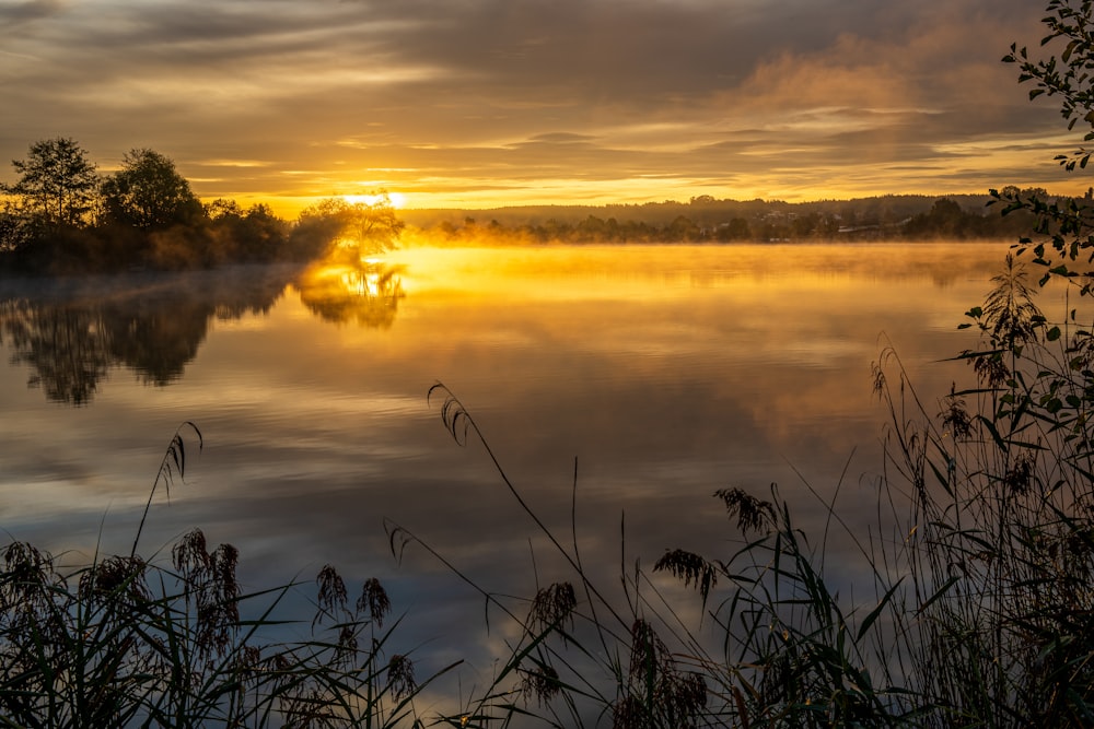 El sol se está poniendo sobre un lago tranquilo