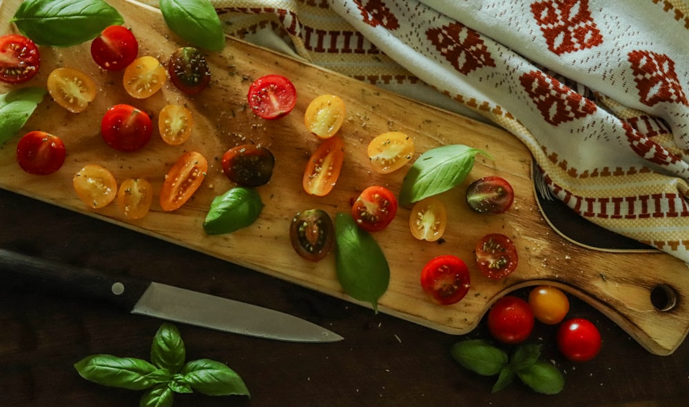 a cutting board with tomatoes and basil on it