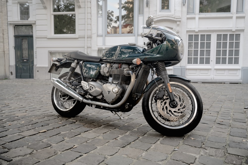 a motorcycle is parked on a cobblestone street