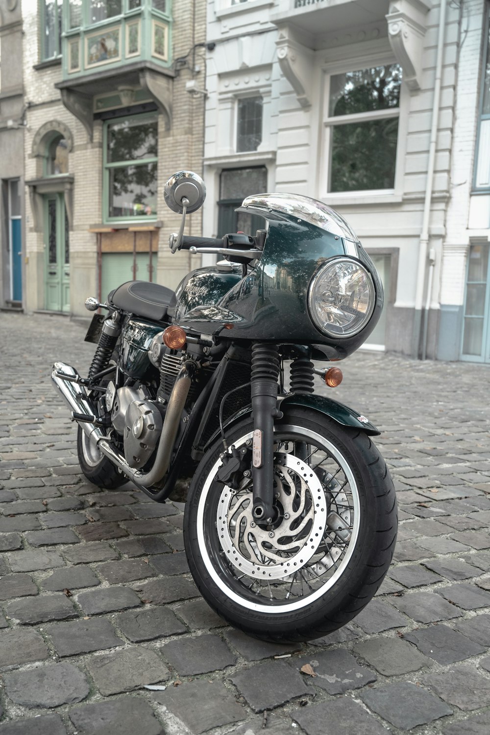 a motorcycle is parked on a cobblestone street