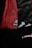 A close-up of a red mesh fabric with a sewn patch featuring a letter. The background is dark, adding contrast to the vivid red color.