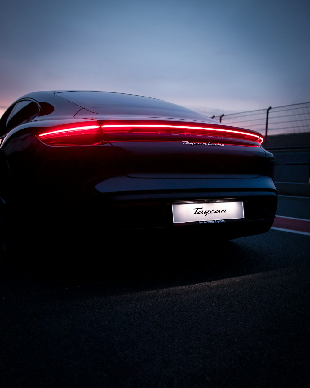 a black sports car driving down a road