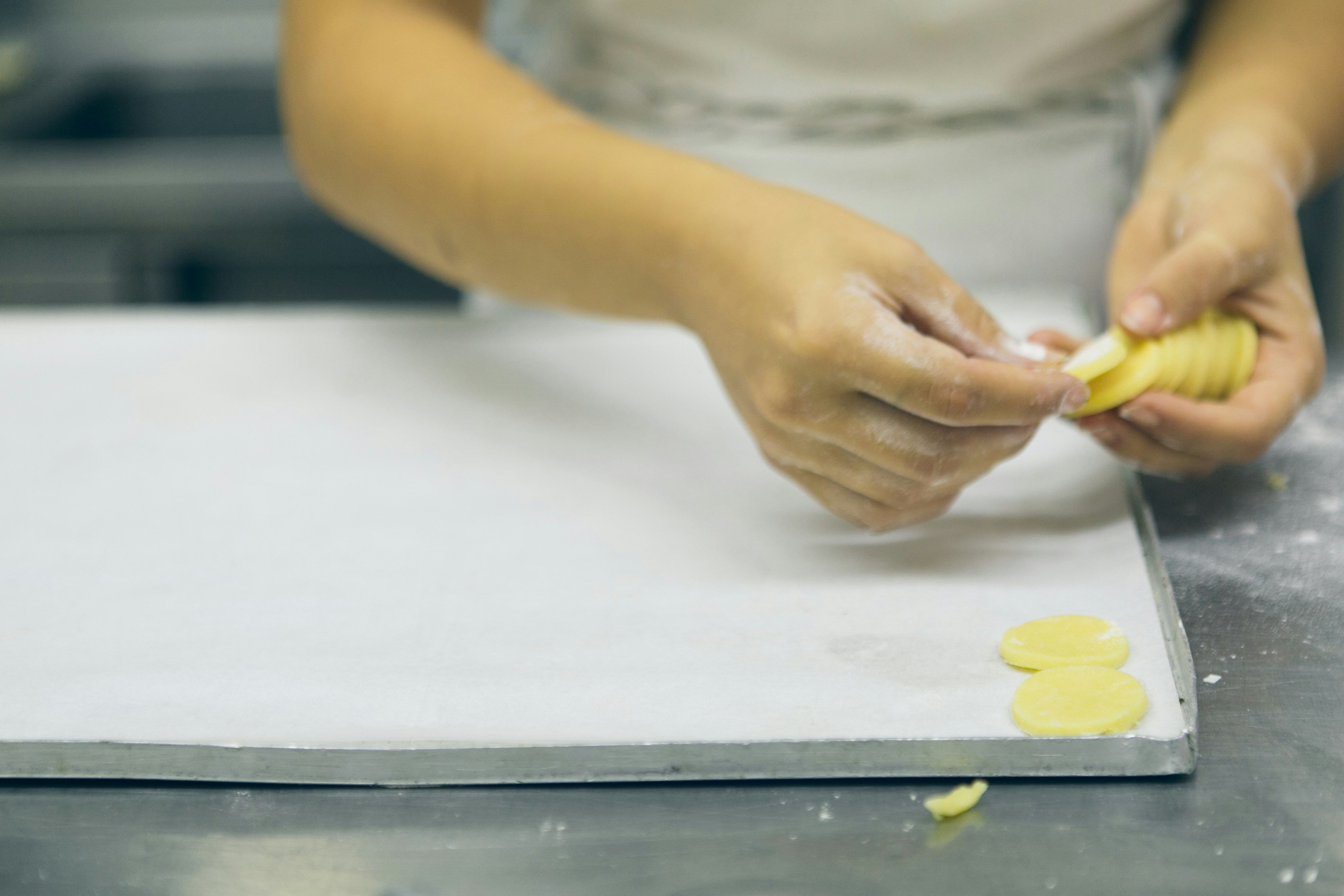 a person in a kitchen peeling a piece of food