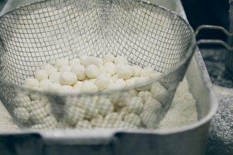 a mesh container filled with white balls of food