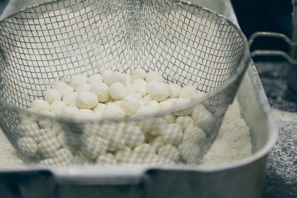 a mesh container filled with white balls of food