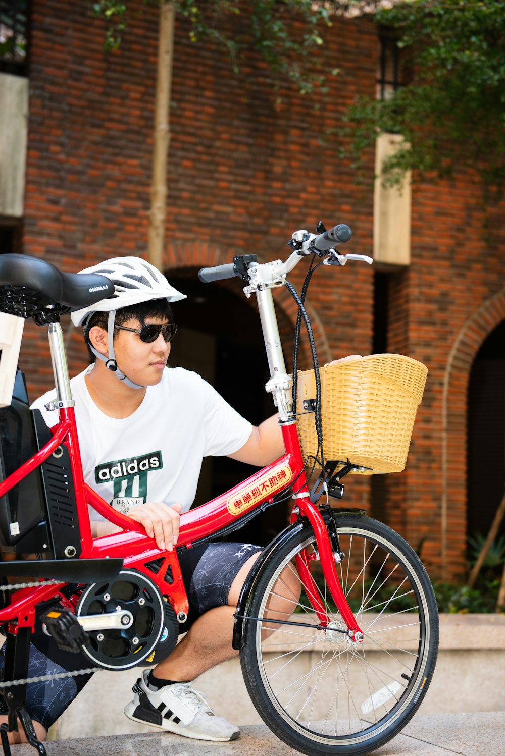 a man sitting on a red bike with a basket