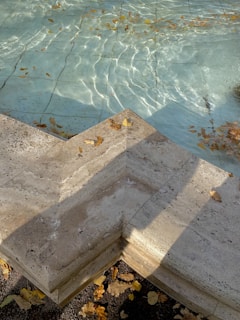 Beautifully finished backyard swimming pool with stone edging and clear water.