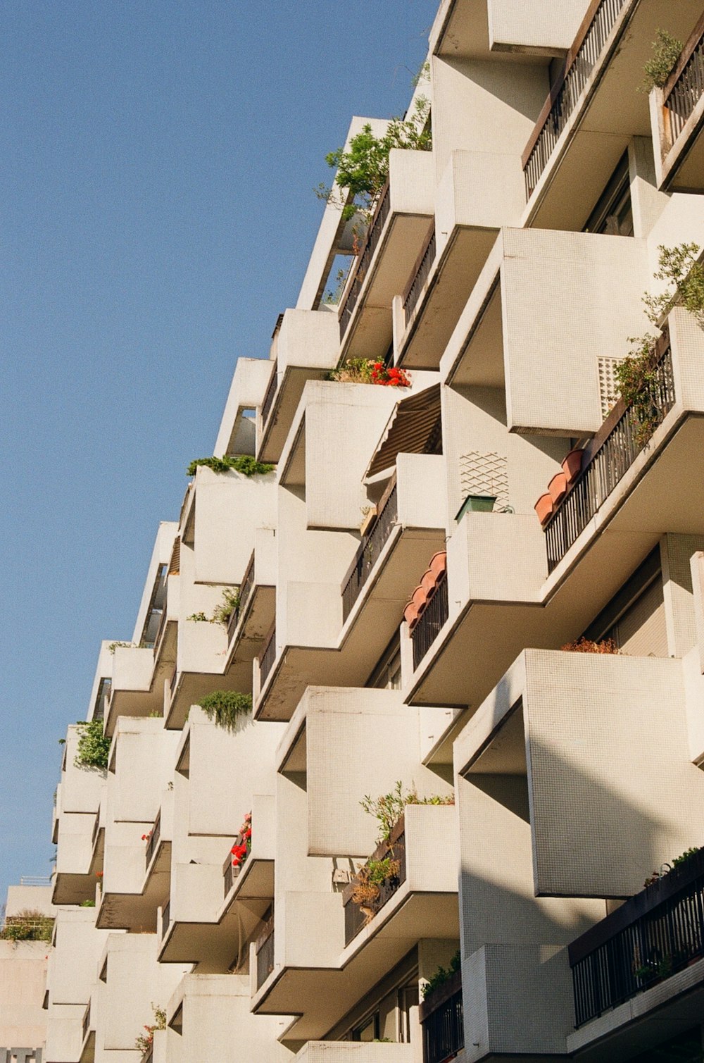 a tall building with balconies and plants on the balconies